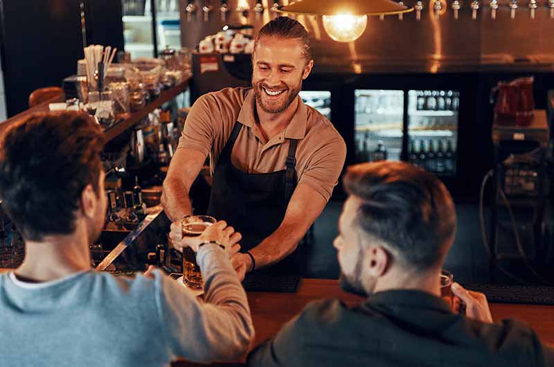 Bartender serving drinks at bar